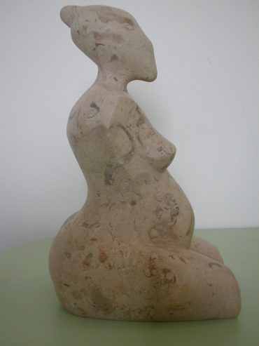 Sculpture d'une femme enceinte en pierre de cassis.