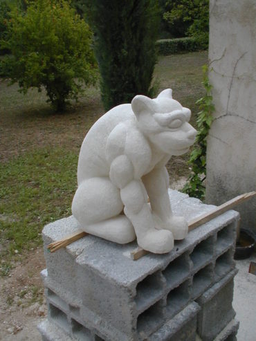 Une chimère réalisée en pierre, assise paisiblement.