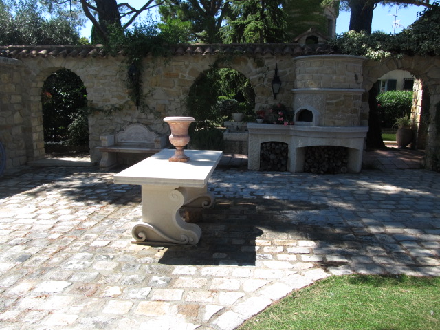 Vase et table en pierre dans un patio.