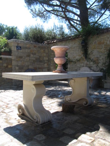 Une table et un vase pour l'aménagement extérieur d'un patio provençal, sculptés dans des pierres différentes.