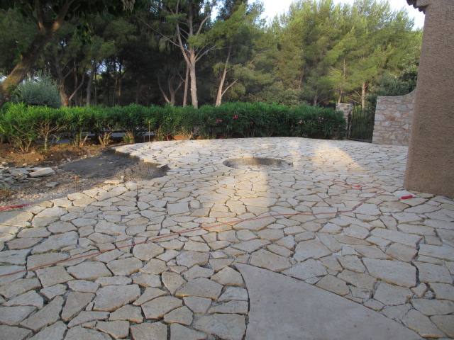 Dallage d'une terrasse dans un style ancien, avec des pavé en pierre imbriqués.